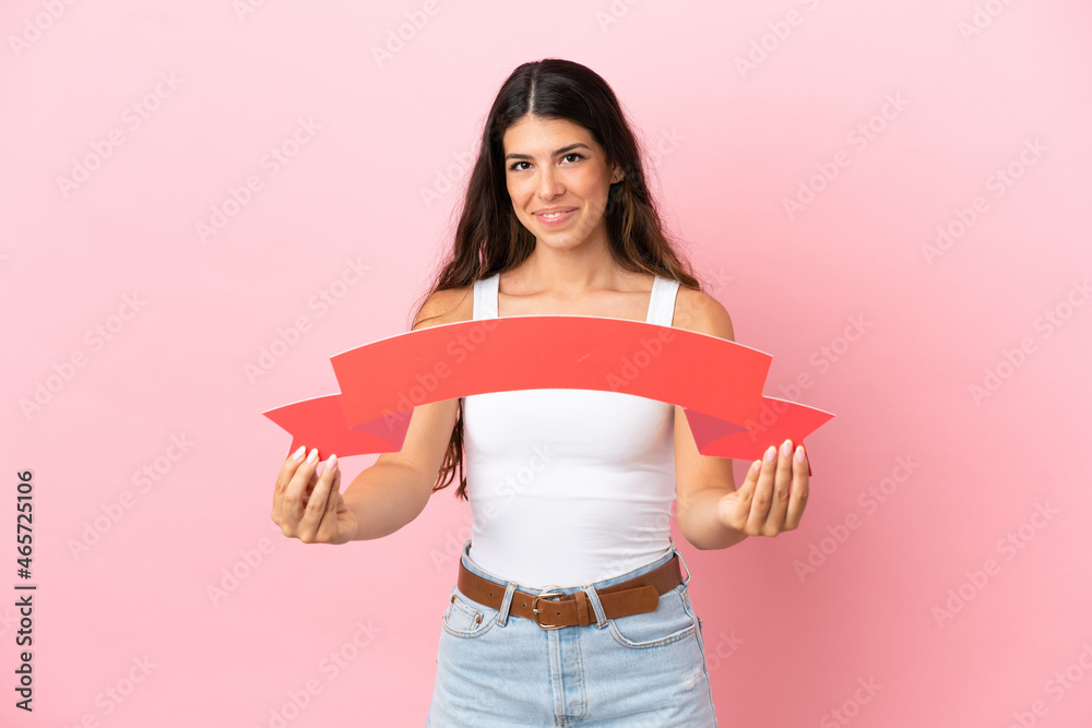 Young caucasian woman isolated on pink background holding an empty placard Young caucasian woman isolated on pink background holding an empty placard