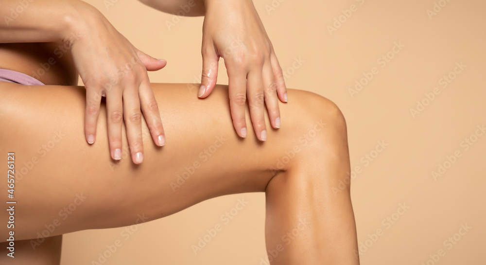 Close-up on a woman applying cream on her legs
