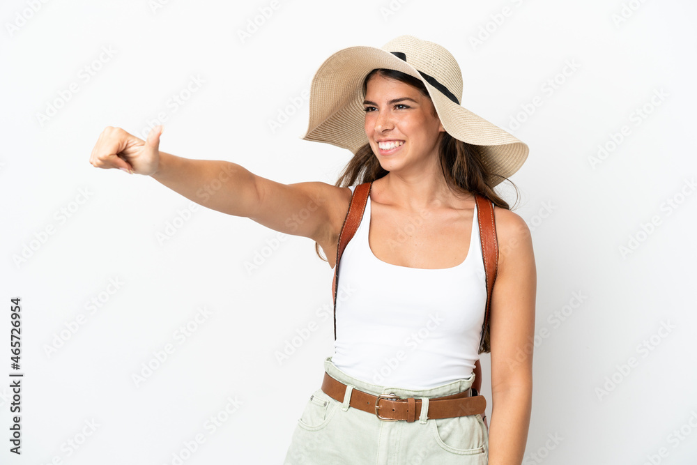 Young caucasian woman wearing a Pamela in summer holidays isolated on white background giving a thumbs up gesture Young caucasian woman wearing a Pamela in summer holidays isolated on white background giving a thumbs up gesture