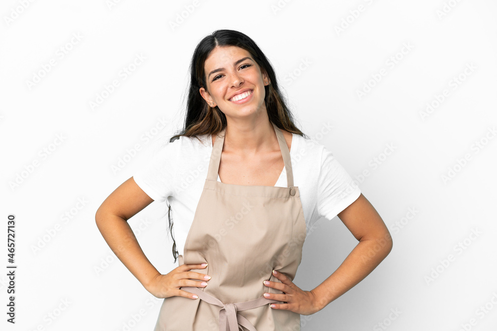 Restaurant waiter over isolated white background posing with arms at hip and smiling