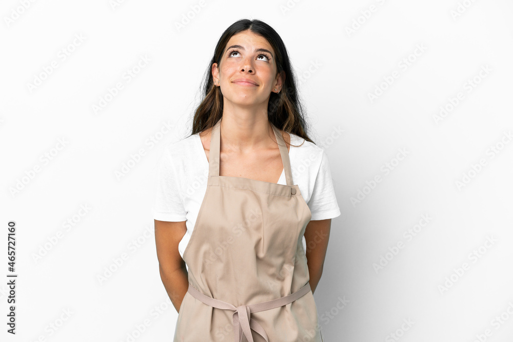 Restaurant waiter over isolated white background and looking up Restaurant waiter over isolated white background and looking up