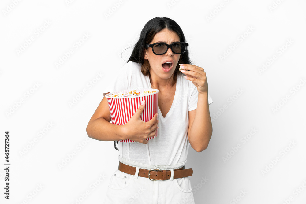 Young caucasian woman isolated on white background with 3d glasses and holding a big bucket of popcorns Young caucasian woman isolated on white background with 3d glasses and holding a big bucket of popcorns