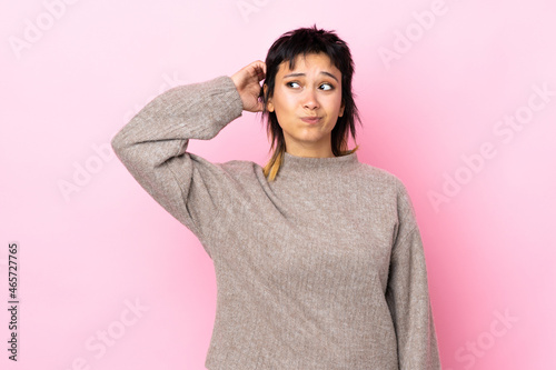 Young Uruguayan woman over isolated pink background having doubts © luismolinero