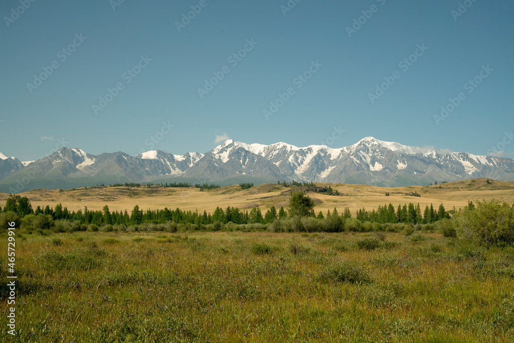 Fototapeta premium Nice view of snowy mountains and steppe in summer