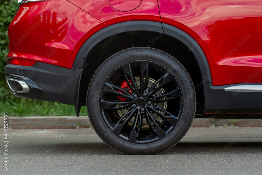 A close up of wheel disk and the side of car. Car wheel on a car.