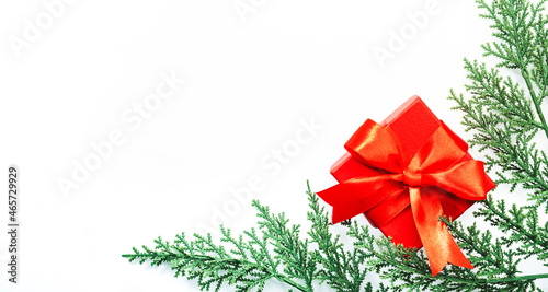 White Christmas and New Year background with red gift box and green coniferous branches. Top view with copy space