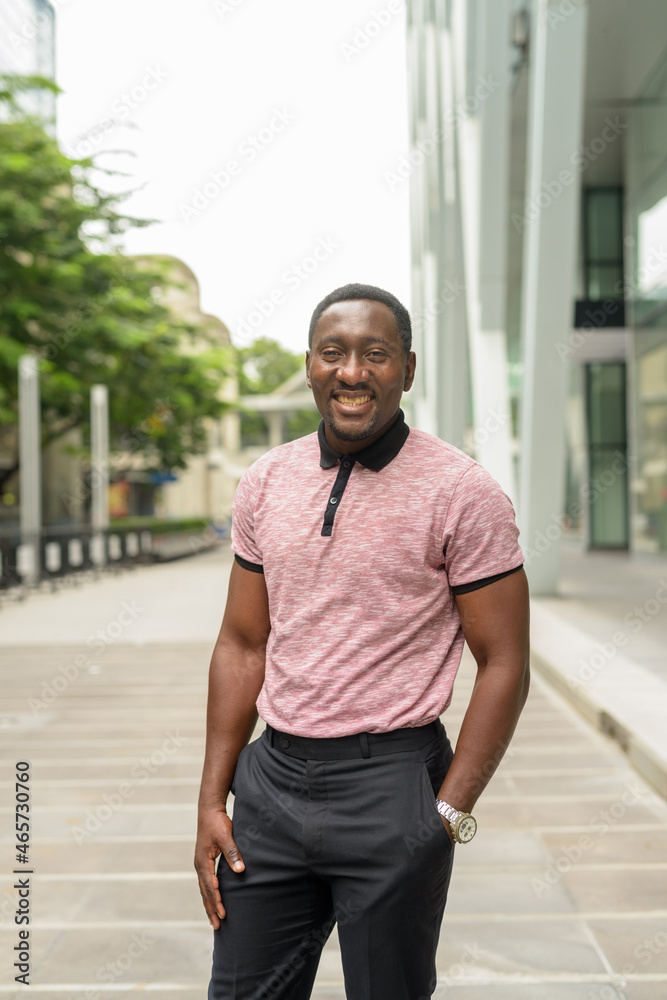 Portrait of handsome African businessman in city smiling Portrait of handsome African businessman in city smiling