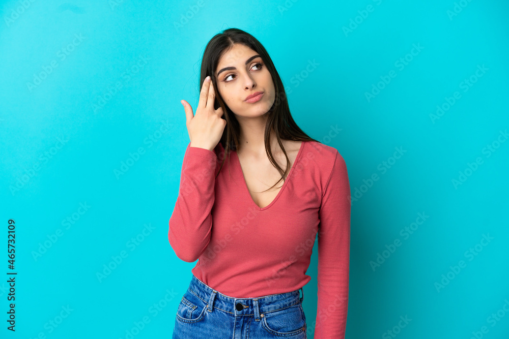 Young caucasian woman isolated on blue background with problems making suicide gesture Young caucasian woman isolated on blue background with problems making suicide gesture