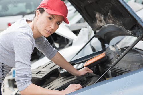 busy female mechanic working on car engine outdoors photo