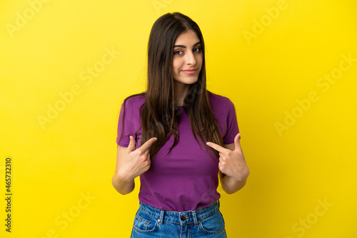 Young caucasian woman isolated on yellow background pointing to oneself