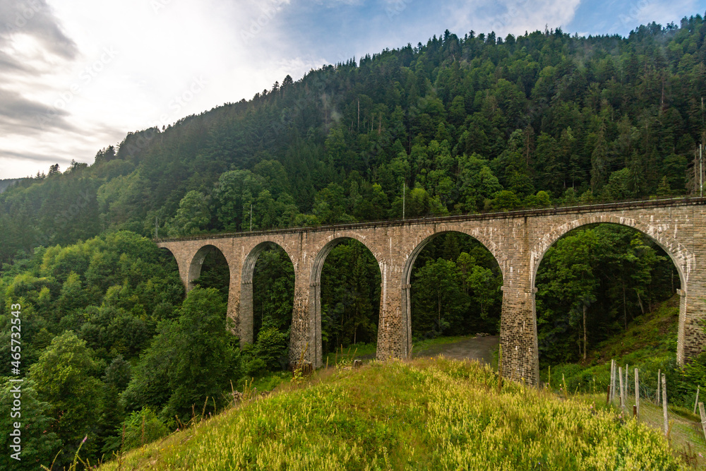 Historic railway bridge with a yellow train at the Ravenna Gorge Black Forest