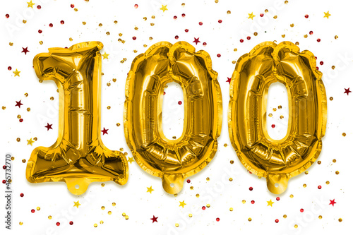 The number of the balloon made of golden foil, the number one hundred on a white background with multicolored sequins. Birthday greeting card with inscription 100. Anniversary concept.