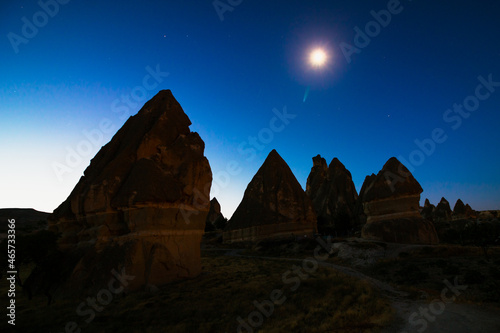 Silhouette of Fairy Chimneys or Peri Bacalari and Moon at Sunrise. Morning view of Cappadocia. Tourism in Turkey. Fairy chimneys in Cappadocia Goreme Nevsehir.