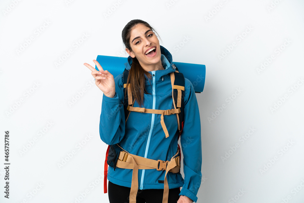 Young mountaineer man with a big backpack over isolated background smiling and showing victory sign Young mountaineer man with a big backpack over isolated background smiling and showing victory sign