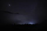 Beautiful view of misty mountains under starry sky at night
