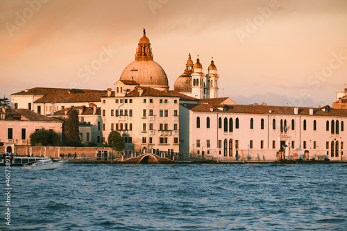 Old buildings on Dorsodouro promenade and cupola of Santa Maria della Salute church in Venice, Italy. Traditional Venetian architecture and footbridge. Toned image. © tilialucida