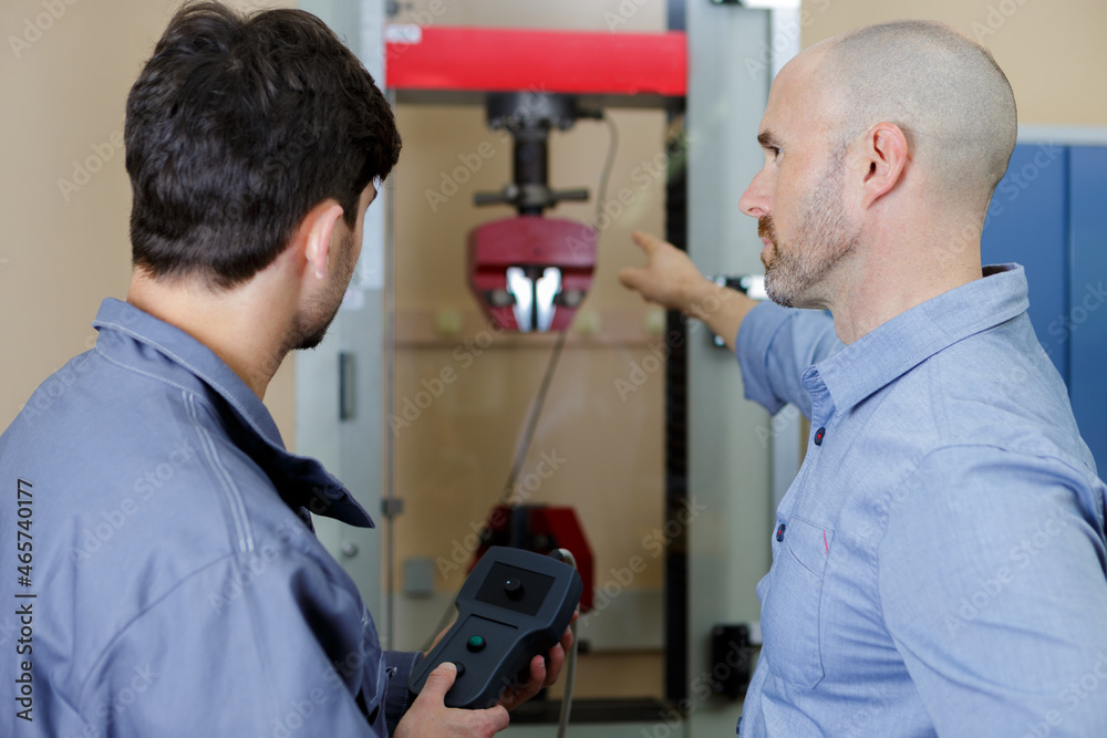 man training new recruit how to operate machinery remotely man training new recruit how to operate machinery remotely