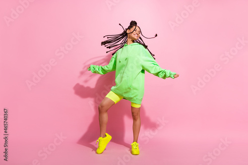 Full body photo of nice dark skin pretty cheerful woman fly hair good mood smile isolated on pink color background