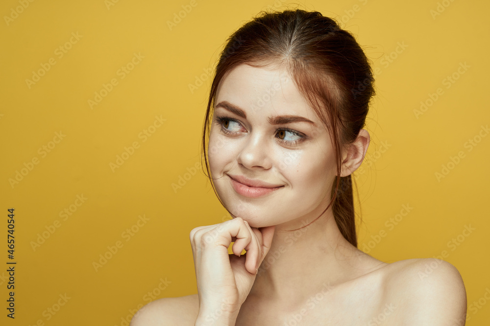 pretty woman naked shoulders and posing clear skin yellow background pretty woman naked shoulders and posing clear skin yellow background