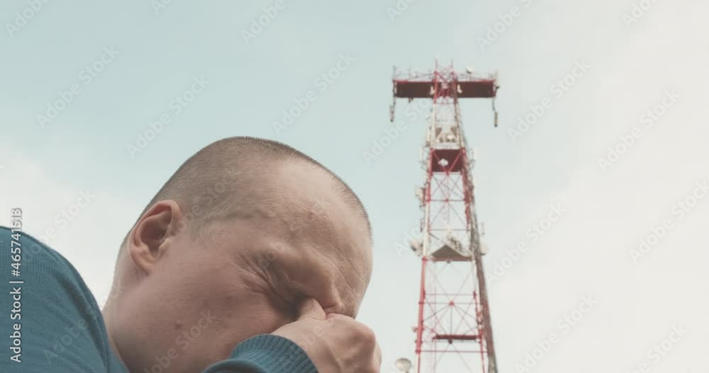 Vidéo Stock 4G and 5G cellular radio tower, the man has a bad headache