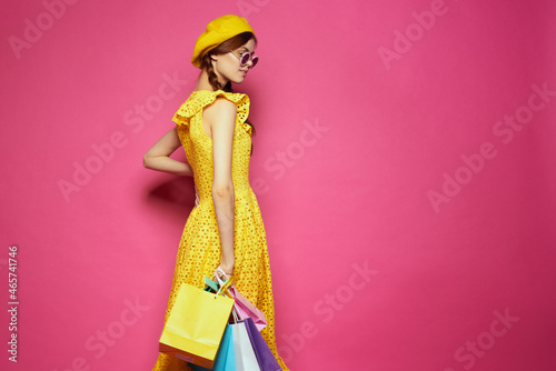 cheerful woman wearing sunglasses posing shopping fashion pink background
