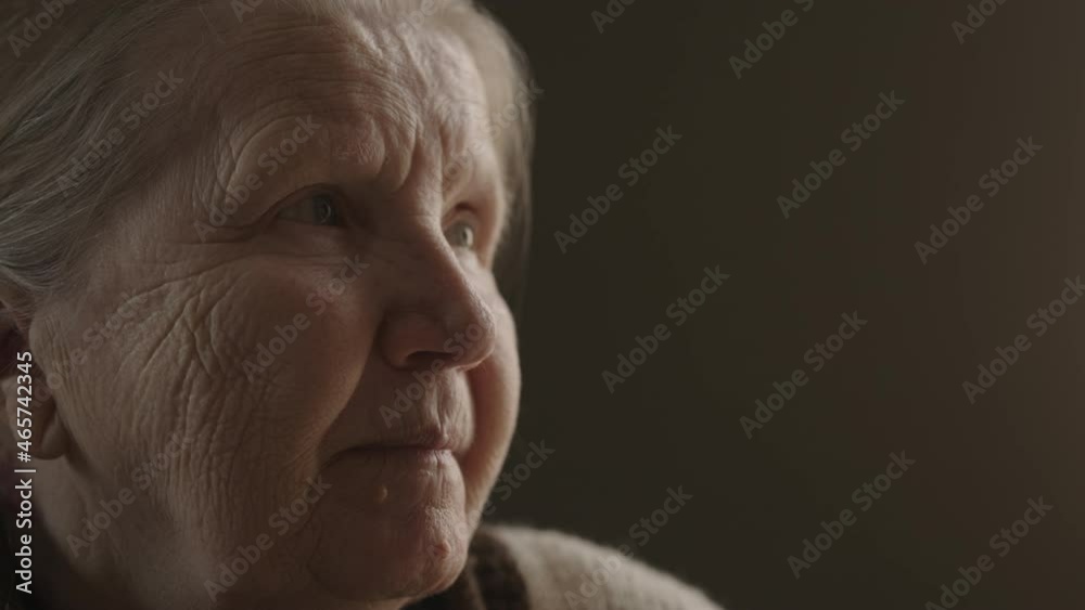 Senior woman sitting indoor with soft window light Senior woman sitting indoor with soft window light