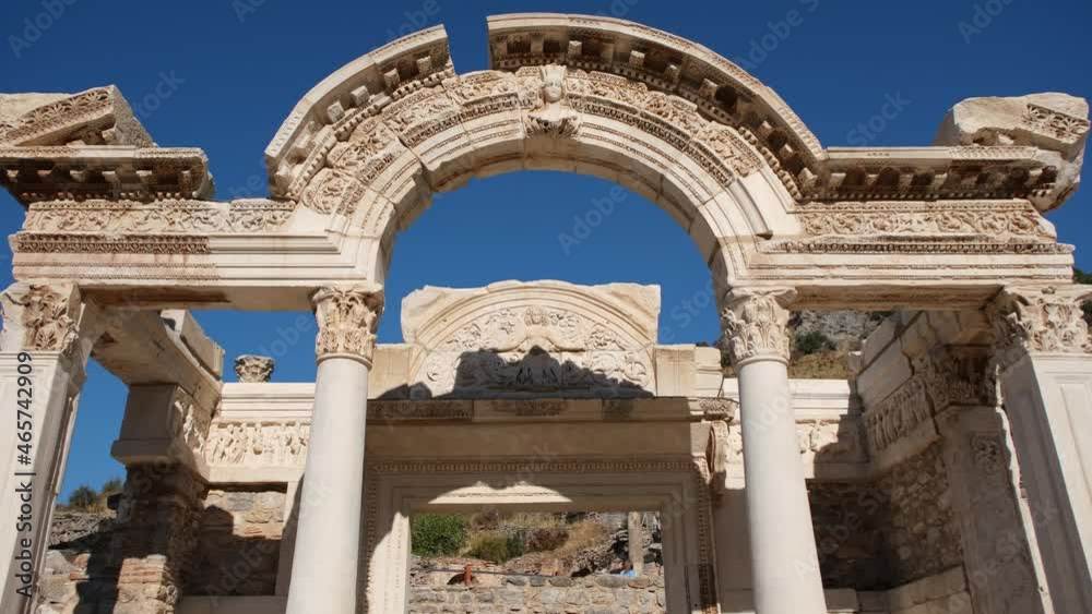 Old architectural and pillar at one part of the Library of Celsus, Ephesus, Izmir Turkey. Travel destination of marble arch and sculpture in a classical greek era, Anatolia under a blue sky. Old architectural and pillar at one part of the Library of Celsus, Ephesus, Izmir Turkey. Travel destination of marble arch and sculpture in a classical greek era, Anatolia under a blue sky.