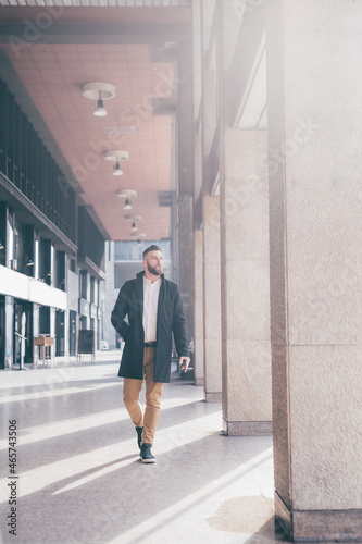 Young elegant business man walking outdoors smoking cigarette © Eugenio Marongiu