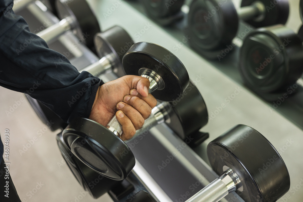 Young Fitness man with dumbbell in gym. Guy weight training wearing sportswear. Asian man exercise indoor gym lifting dumbbell. Bodybuilder good health Young Fitness man with dumbbell in gym. Guy weight training wearing sportswear. Asian man exercise indoor gym lifting dumbbell. Bodybuilder good health