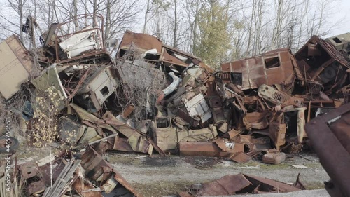 Aerial video. Old abandoned equipment that took part in the elimination of the accident. The village of Rassokha. Chernobyl. Rusty machinery.  photo