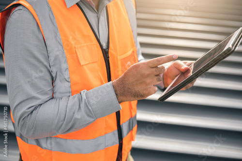 Close up male hands architect or engineer using tablet control planning construction building. Civil engineers work on the roof of a modern building. Standing on the top floor roof with the sunset