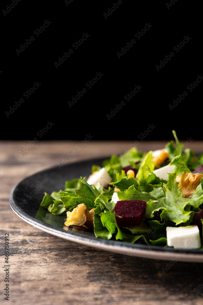 Beetroot salad with feta cheese,lettuce and walnuts on rustic wooden table Beetroot salad with feta cheese,lettuce and walnuts on rustic wooden table