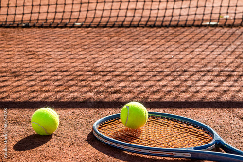 Tennis racket and new tennis ball on a Red clay court. © Ivan