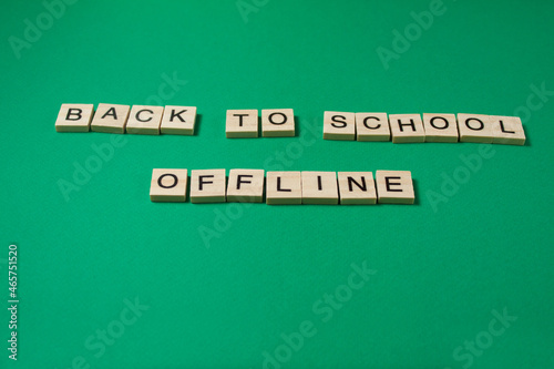 Back to School Offline Text by wooden letters on a green background. Distance education due to pandemic-wide quarantine. Distance learning concept.