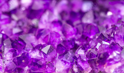 Amethyst purple crystals. Gems. Mineral crystals in the natural environment. Texture of precious and semiprecious stones. Seamless background with copy space colored shiny surface of precious stones.