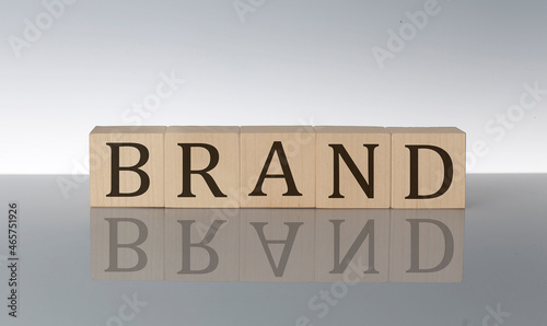 BRAND concept, wooden word block on the grey background