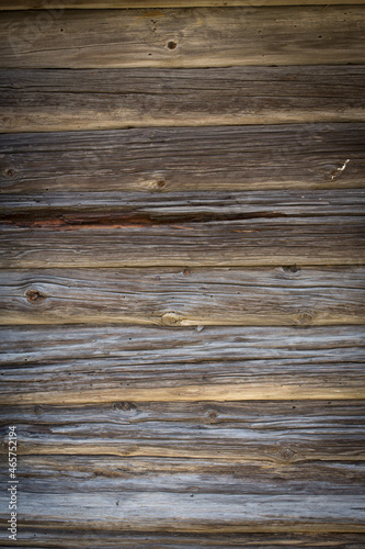 Wooden logs of an old house. Close-up. Weathered natural gray wood texture. Background. vertical photo.