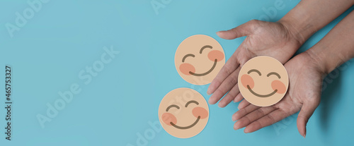 Hand holding nude paper cut happy smile face, positive thinking, mental health assessment , world mental health day concept
