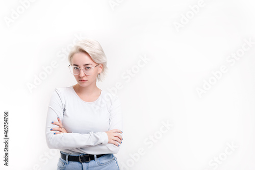 A young blonde girl on a white background folded her hands