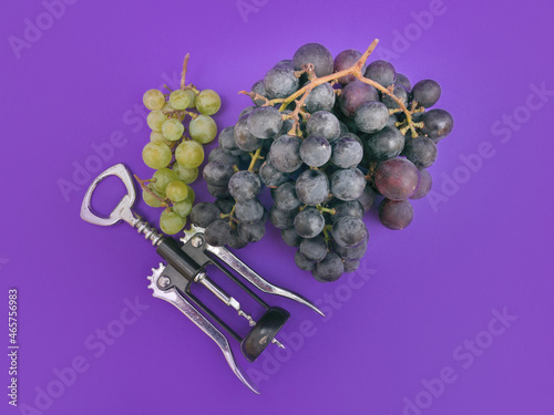 red wine and white grapes and corks on purple background