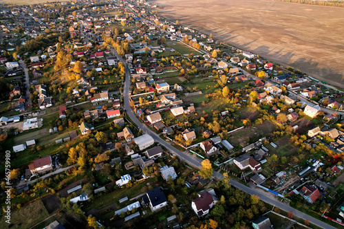 Country houses in the countryside. Aerial view of roofs of green field with rural homes. Village with wooden home. Suburban house at farm. Housing outside the city. Agriculture  farming and agronomy.