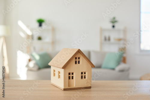 Close up of wooden house model on table in modern real estate agent office. Home building cottage maquette in realtor broker company. Bank property loan mortgage. Rent, realty concept. photo