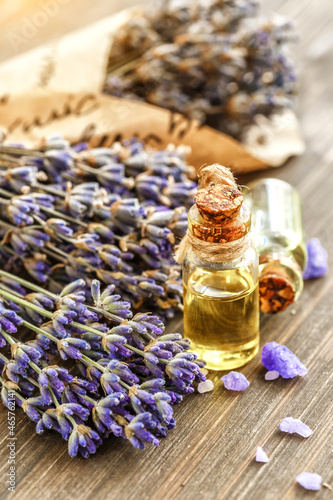 lavender's spa products with dried lavender flowers on a wooden table. Flat lay bath salt and massage oil on wooden background. Skin care, beauty treatment concept. Lavendula oleum