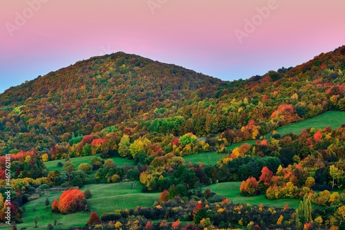 Autumn landscape at dusk with colorful leaves of trees in pastel colors.  With mountains and a beautiful clear purple-pink sky.  Protected area Dubrava , Biele Karpaty Slovakia.  photo