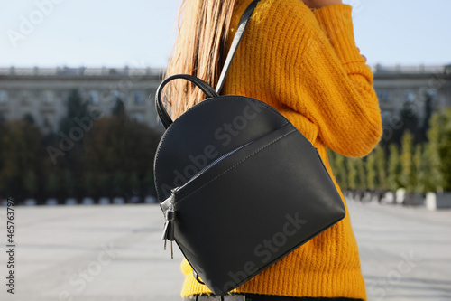 Woman with stylish black backpack on city street, closeup photo