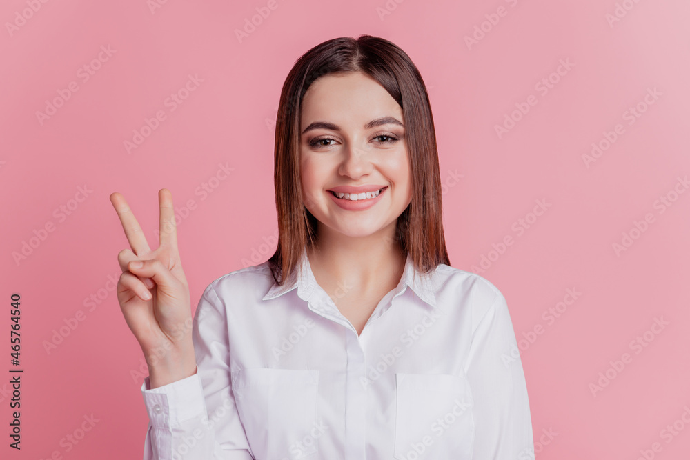Photo of young cheerful lady show fingers peace cool victory v-symbol isolated over pink color background