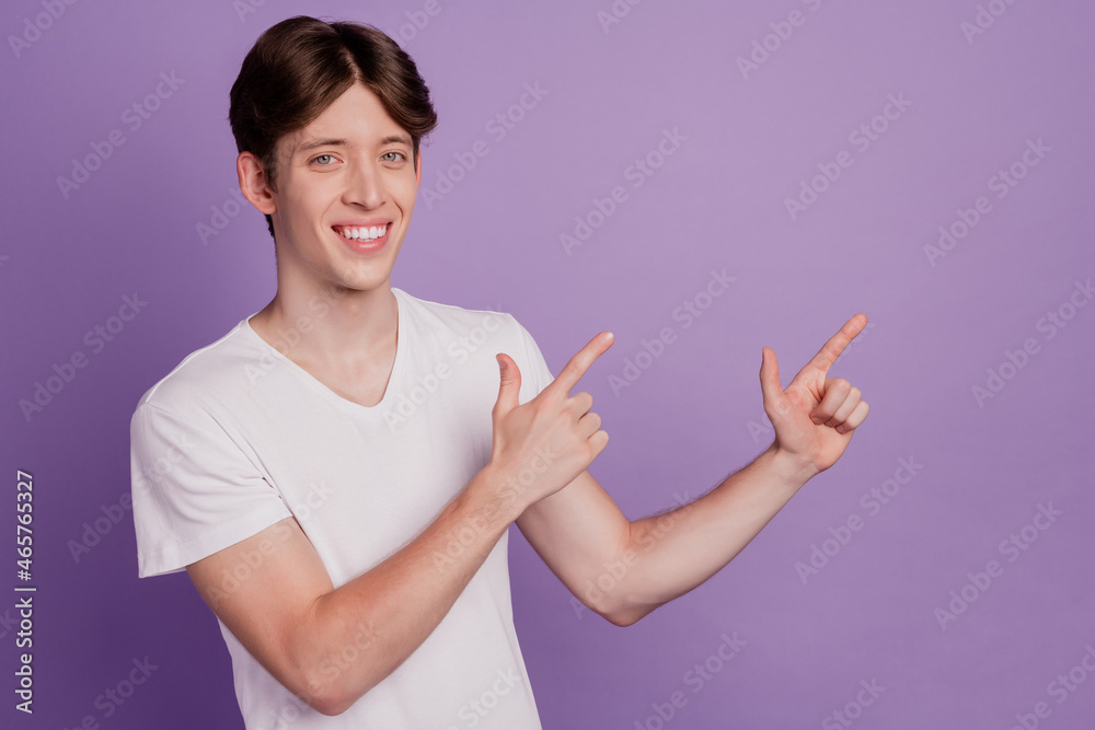 Photo of young guy indicate fingers empty space advertise decide promo isolated over violet color background Photo of young guy indicate fingers empty space advertise decide promo isolated over violet color background