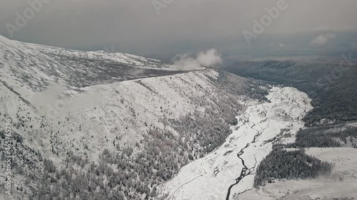 Storm, snowfall in the huge glacier of Mount Belukha, the valley of the Aktru River, the Altai Mountains. Cloudy weather, stone in the snow, storm, wildlife, winter forest, frozen mountain river in