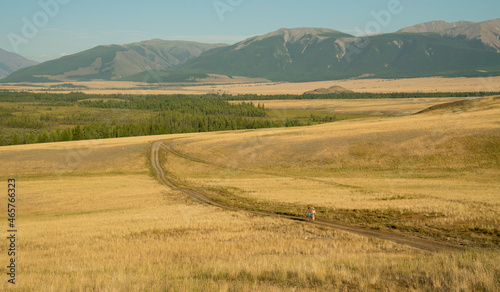 The guy and the girl are traveling on the road to the mountains