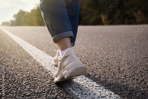 Woman going along road, closeup of legs